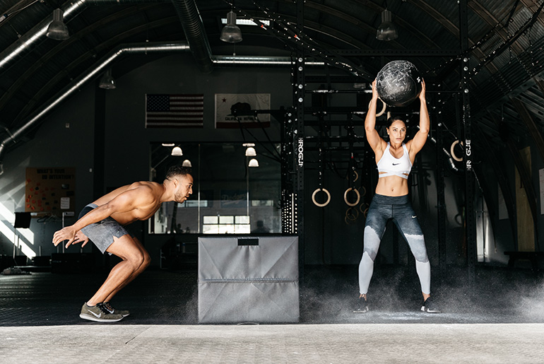 Man And Woman Doing Box Jumps And Medicine Ball Strength Training