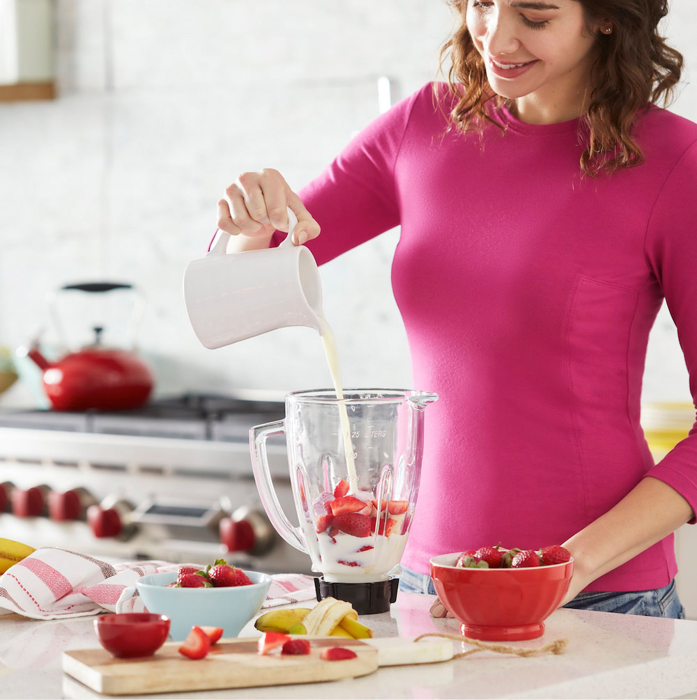 Woman Pouring Milk into Blender
