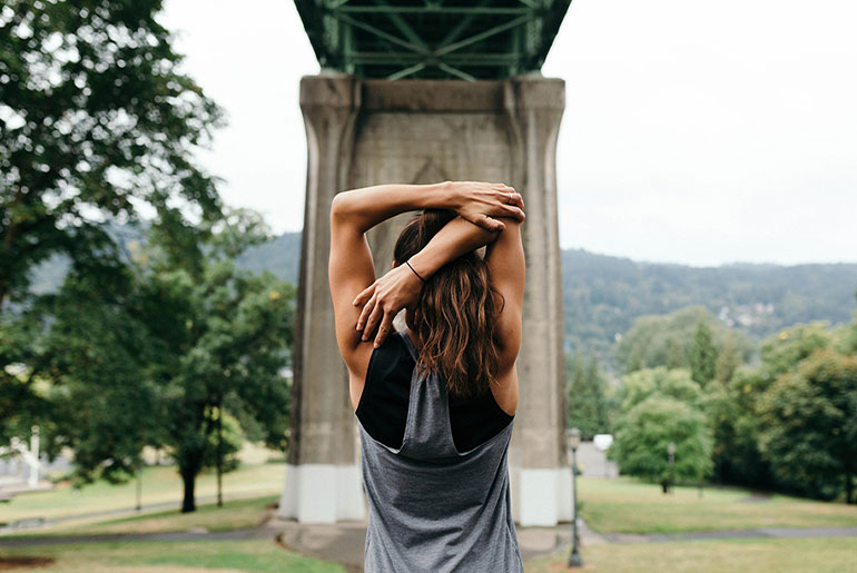 Billede: Kvinde, der strækker armene efter udendørstræning