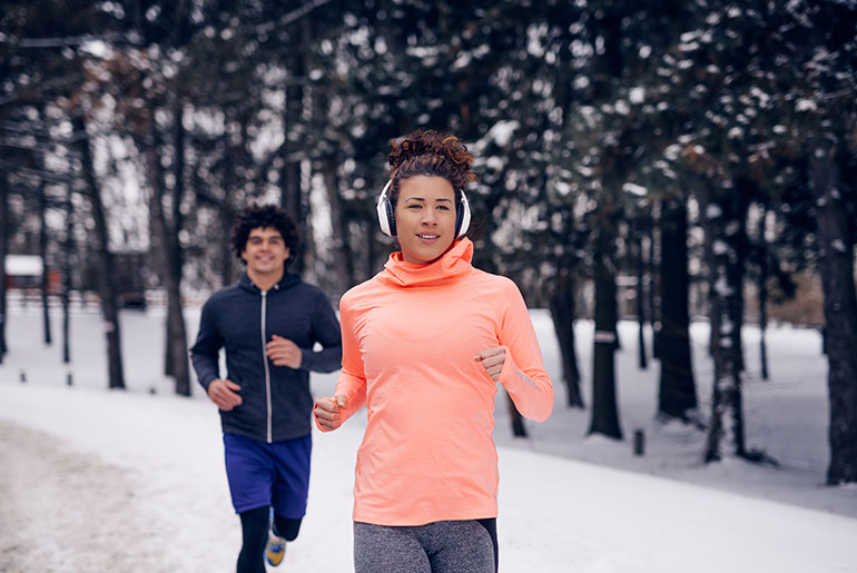 Billede: To personer på vinterferie, der løber udendørs