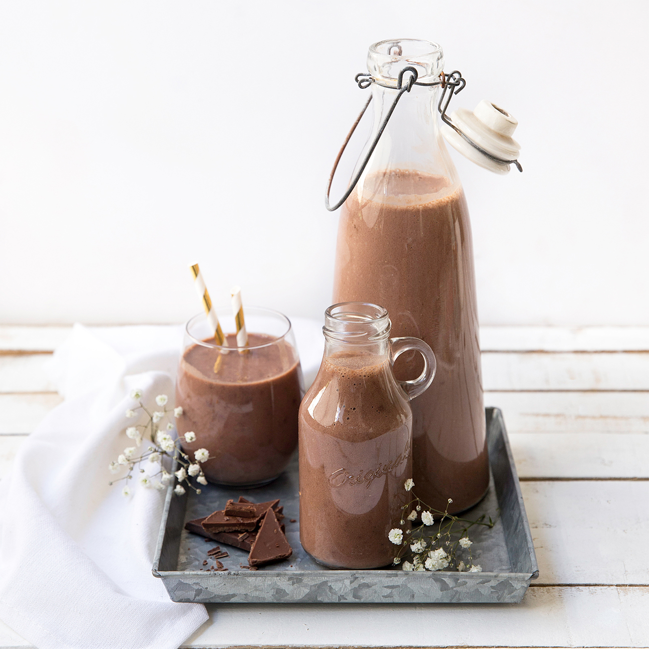 herbalife nutrition formula 1 shake chocolate flavour in glass and jugs on a grey tray