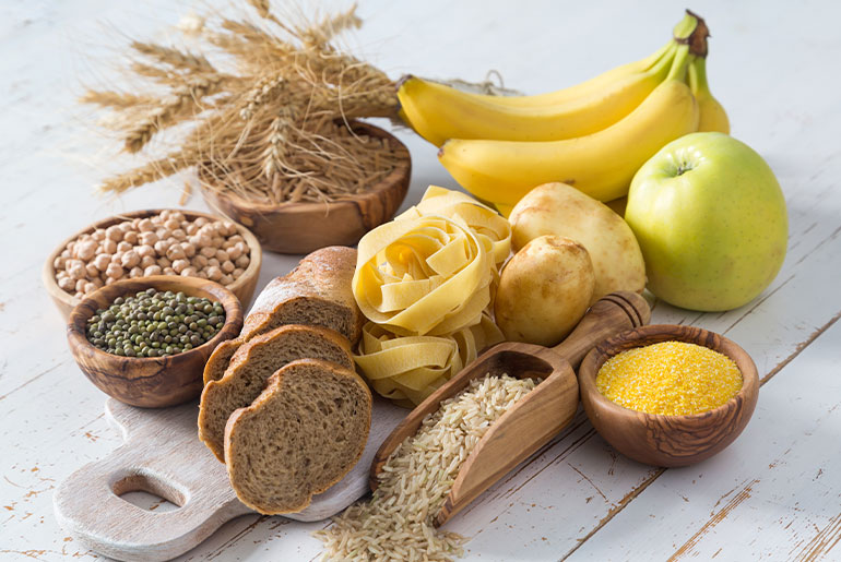 Angle shot of carbohydrate-rich foods placed on a white wood surface