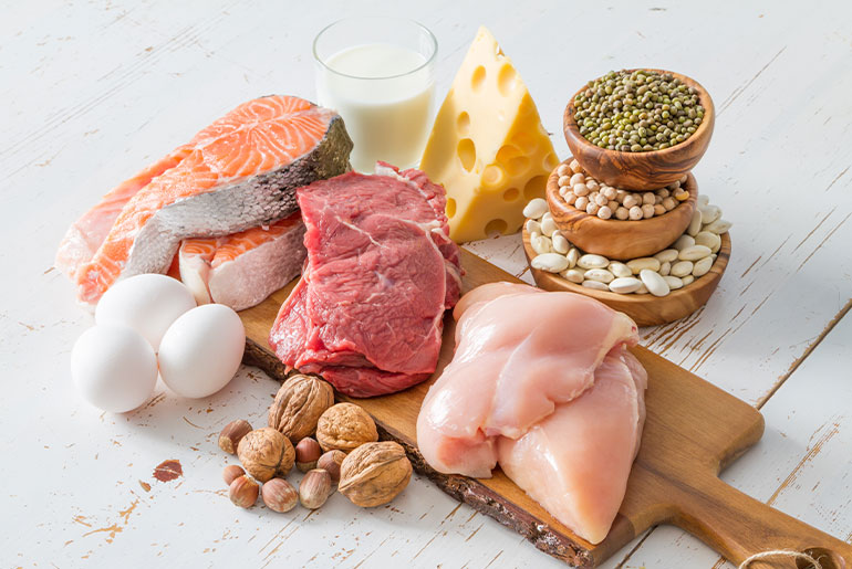 Angle shot of high-protein foods placed on a white wood surface