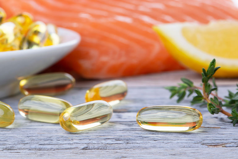 Closeup shot of Omega-3 capsules placed on a rustic wood surface