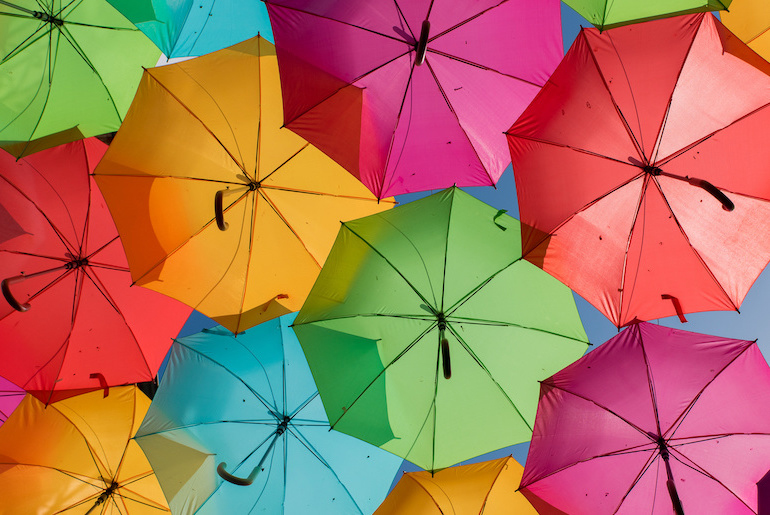 Multiple colourful umbrellas floating in the air
