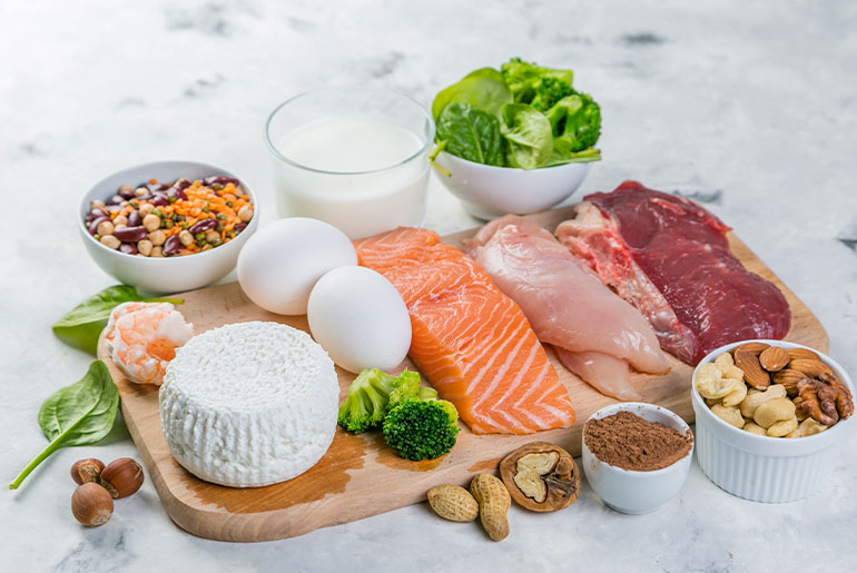 Angle shot of high-protein foods placed on a light grey marble surface