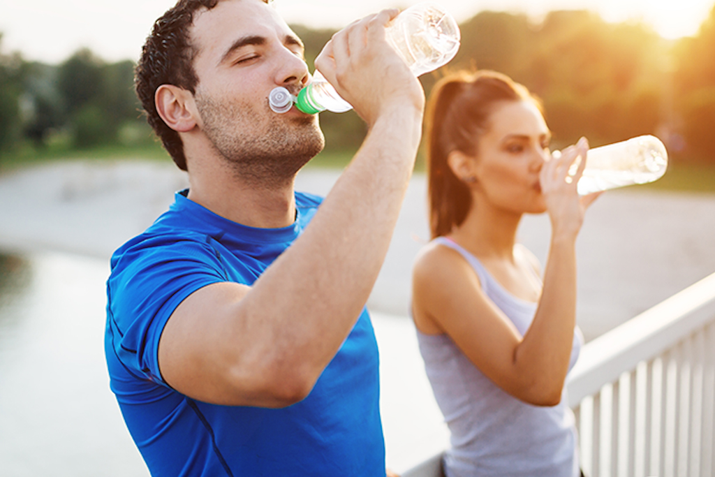 Herbalife Nutrition fitness couple drinkg water while exercise hydration