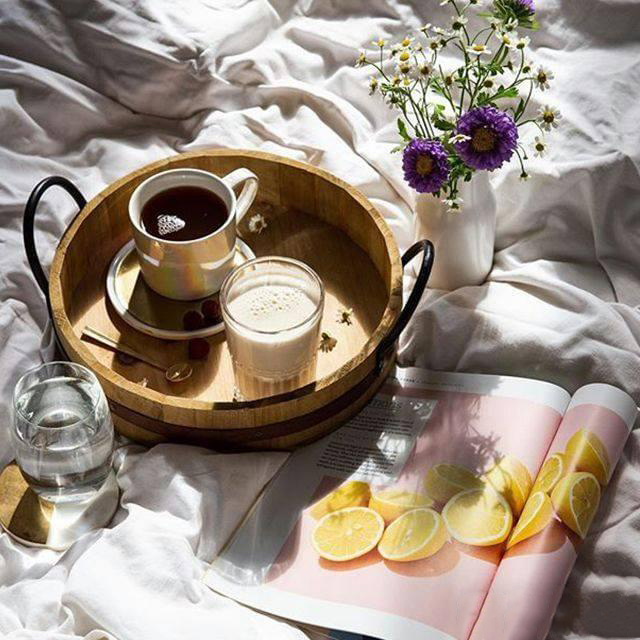 herbalife nutrition healthy breakfast in bed, formula 1 shake, herbal tea and aloe vera drink with flower vase and magazine