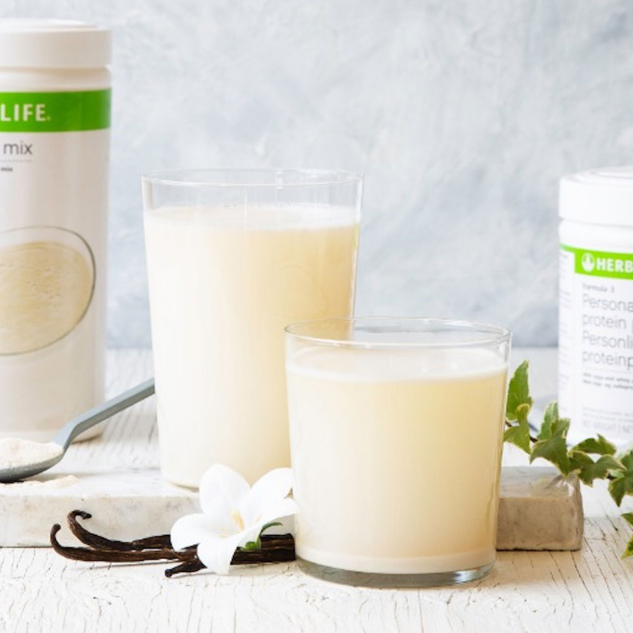 herbalife nutrition vanilla protein shake in a glass with vanilla flower.