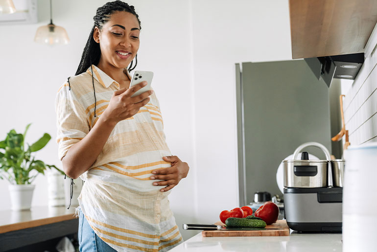 Pregnant woman cooking healthy meal with vegetables