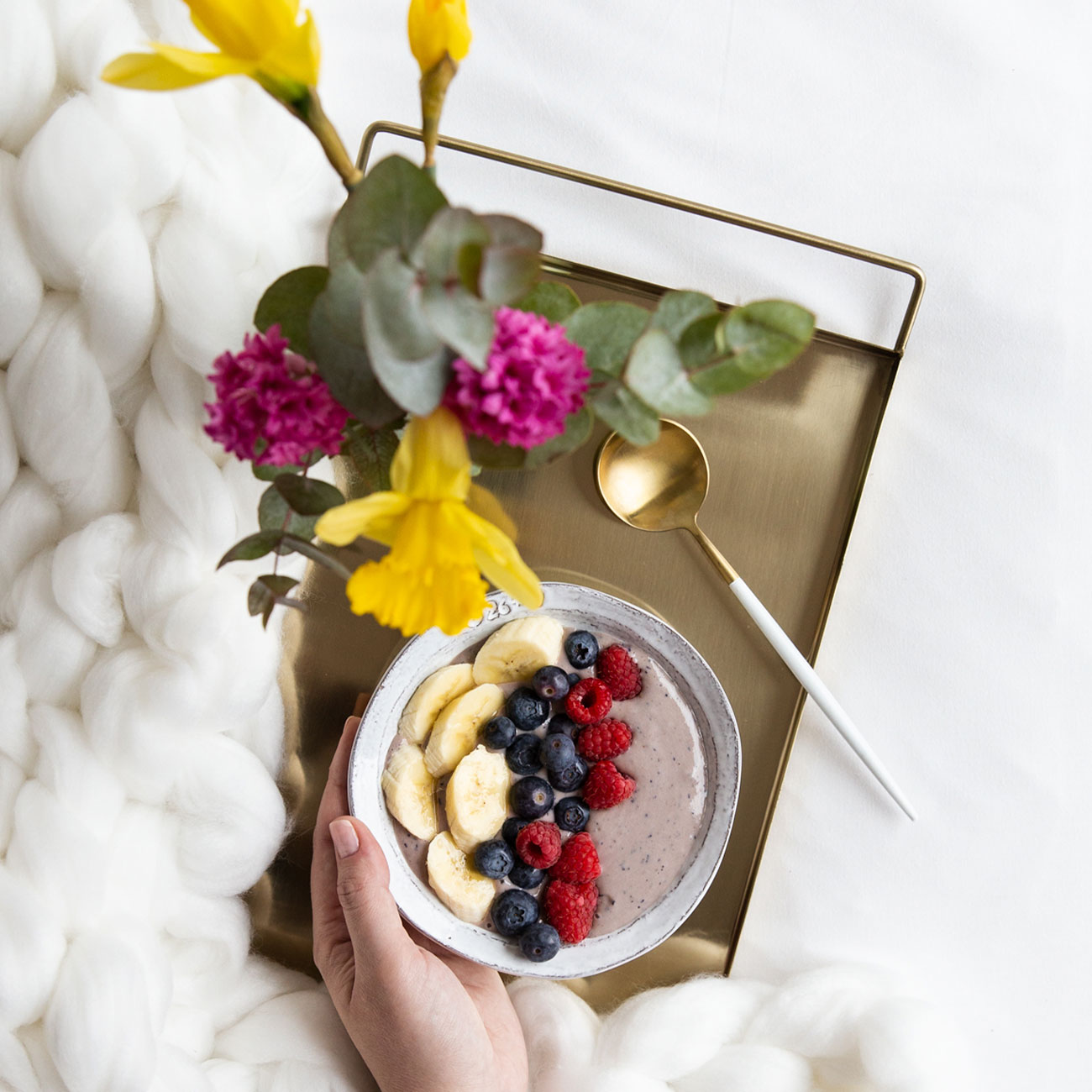 Healthy breakfast banana and berries bowl in bed