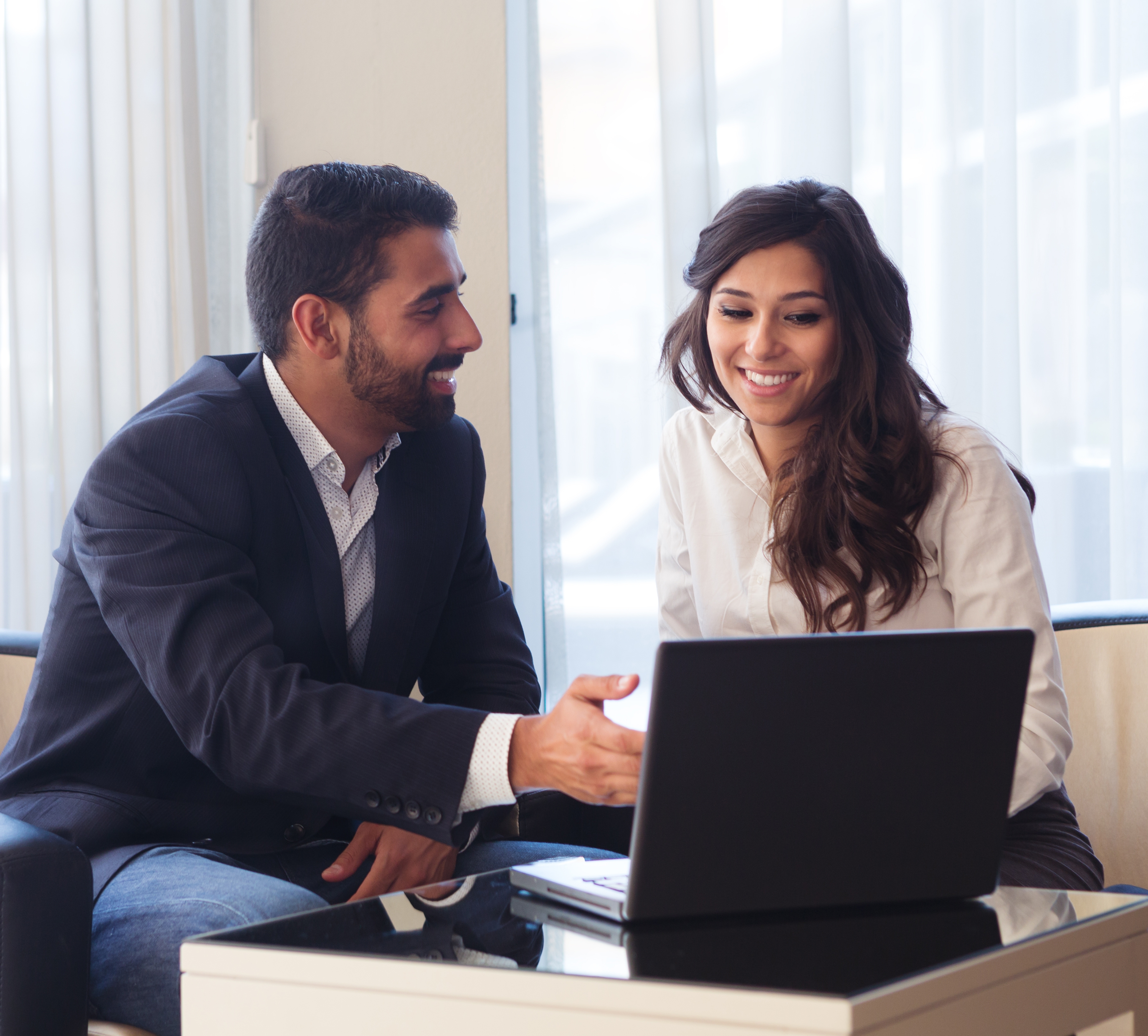 Two people are discussing somethiing on the laptop