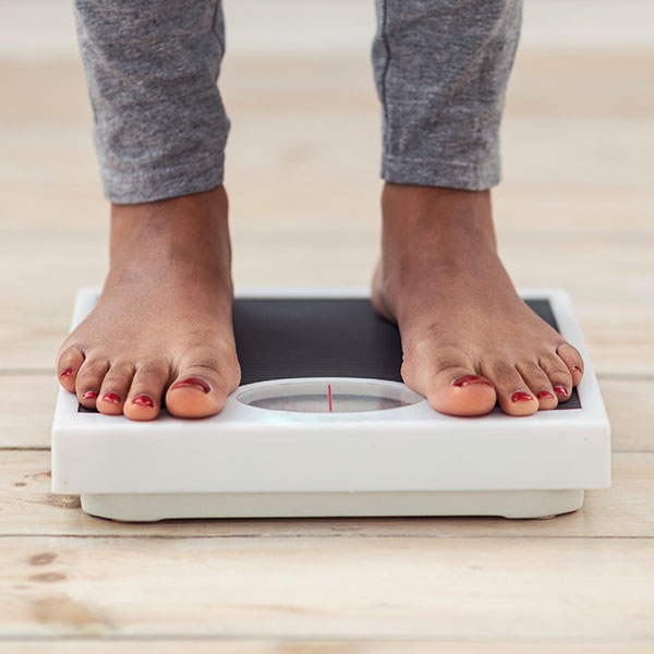 Image of a woman stepping on a scale
