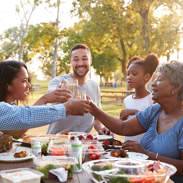 Image of a family having a picnic with healthy food and Herbalife products