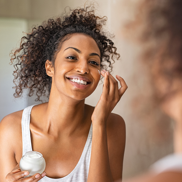 Image of a woman putting on face cream